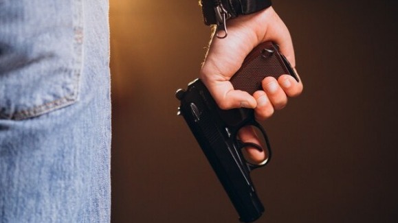 Homem segurando uma arma 